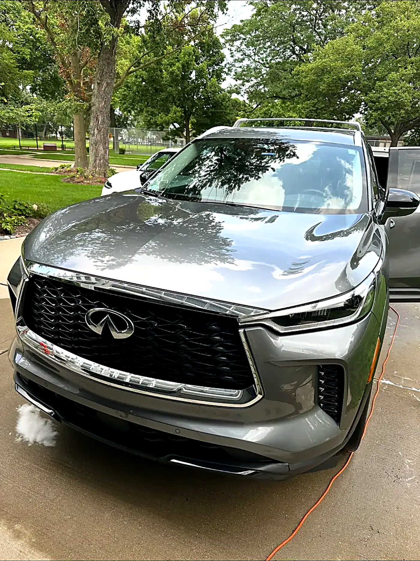 Grey Infiniti QX60 rinsed and gleaming in the driveway after a wash